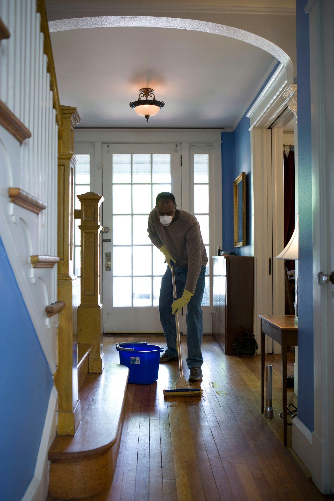 Person mopping a hardwood entryway floor